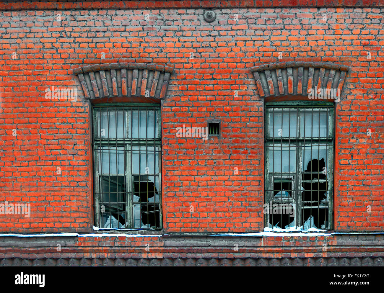 Old broken window on red brick wall Stock Photo