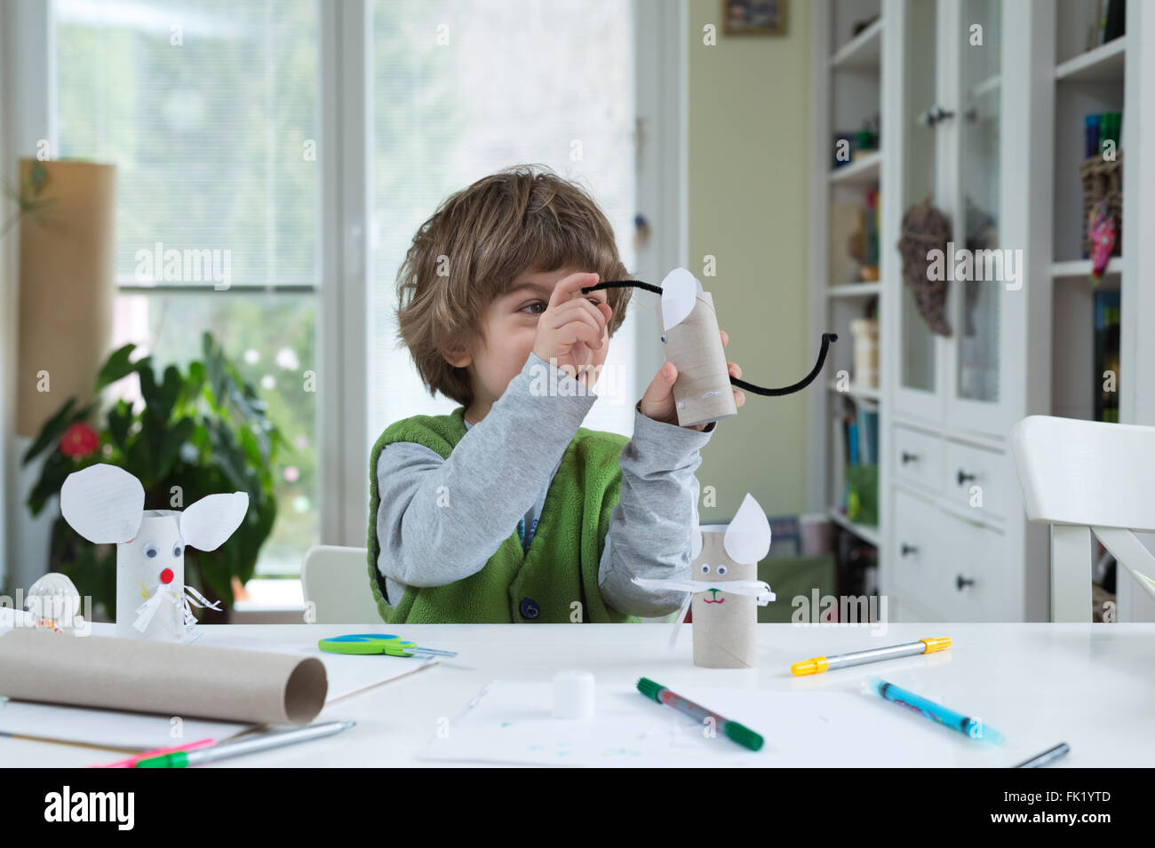 Little boy being creative making homemade paper toys. Supporting ...