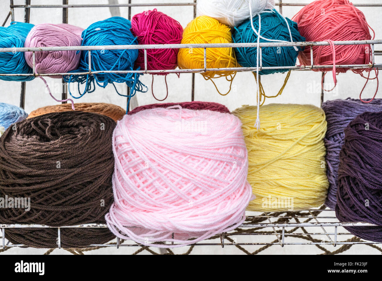 balls of wool in strikingly pure colors artistically arranged on wall shelves in canvas roofed booth at Llano park Friday market Stock Photo