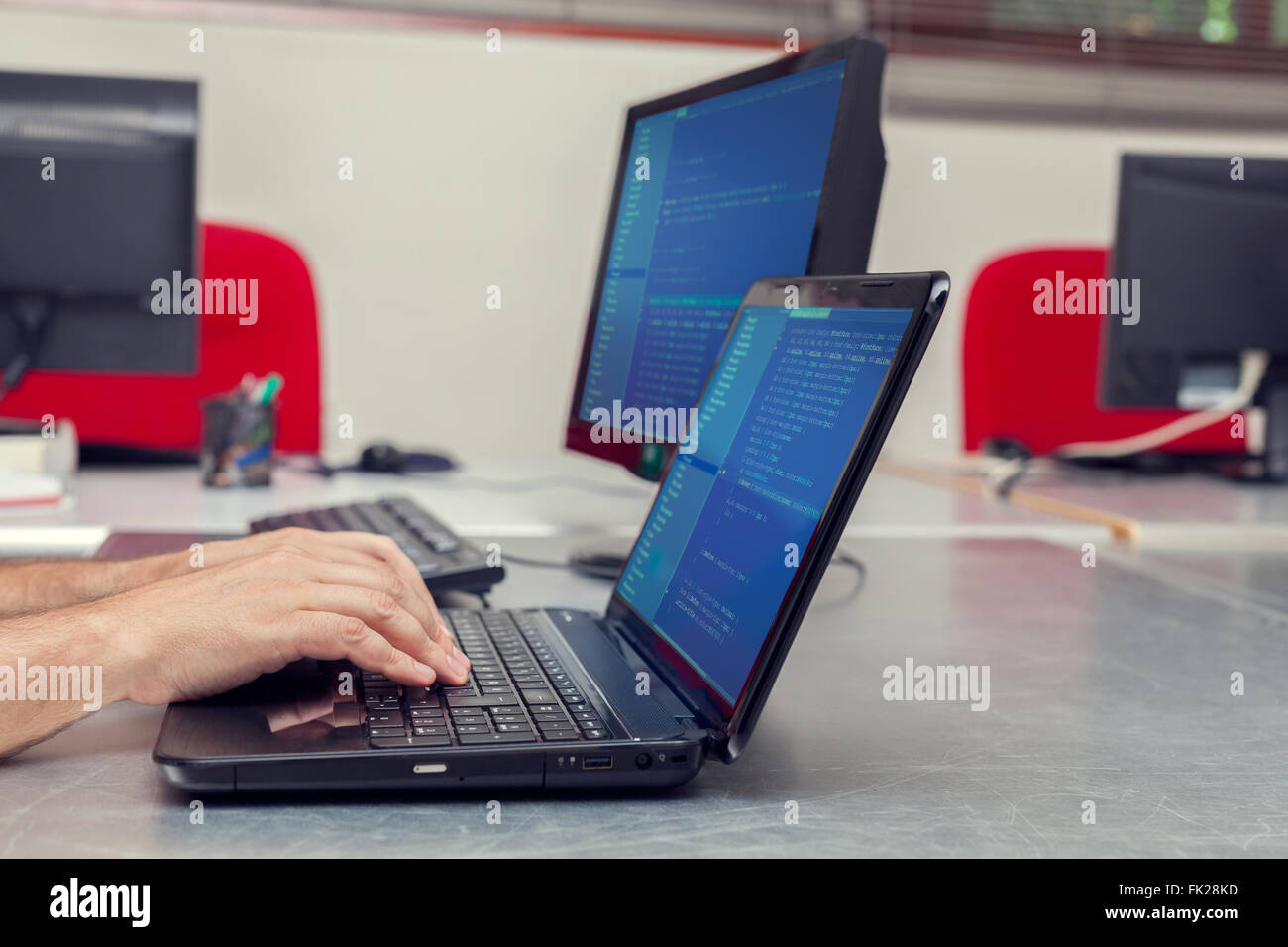 Developer working on source codes on laptop at office. Stock Photo