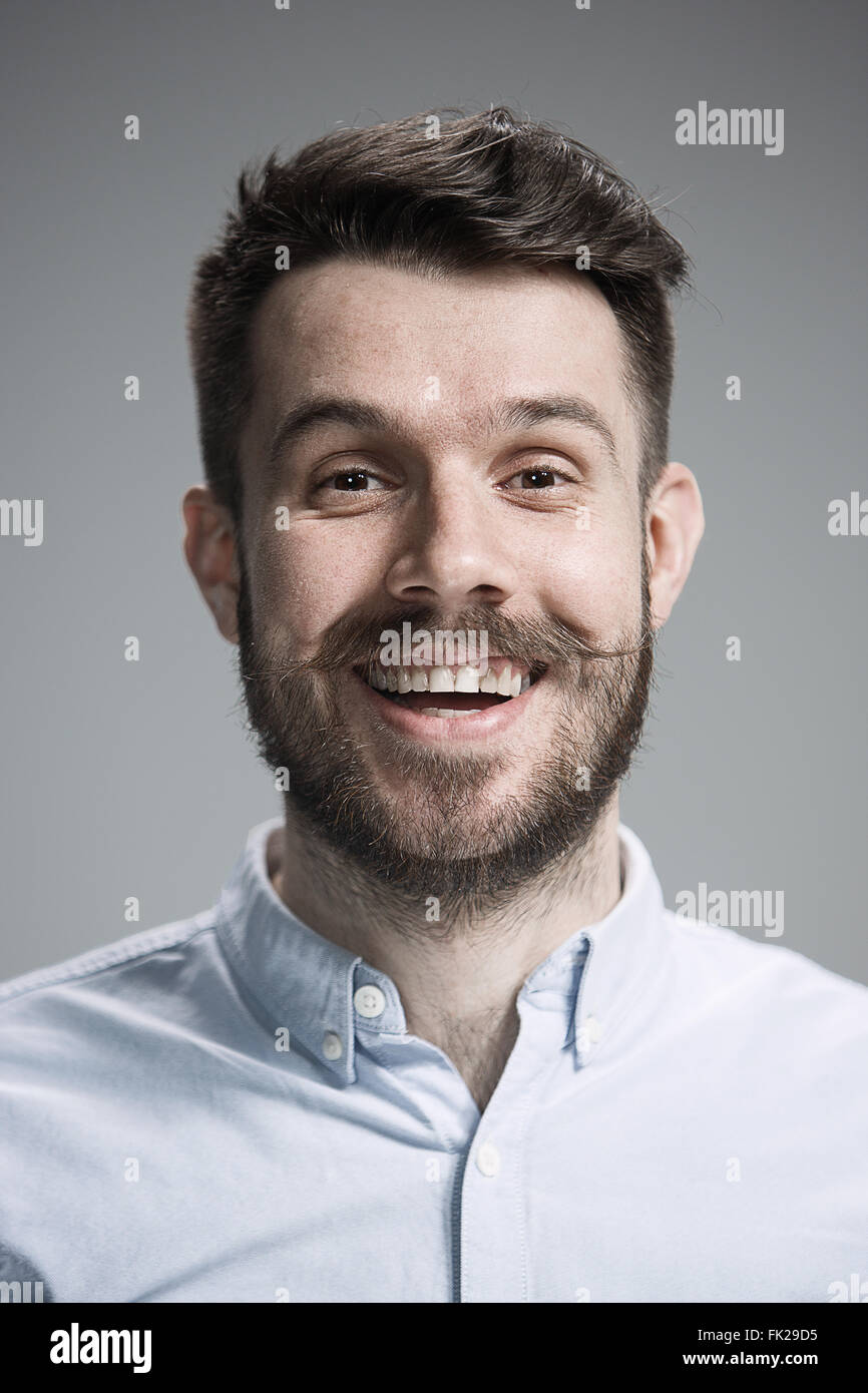 The young happy man looking at camera on gray Stock Photo - Alamy
