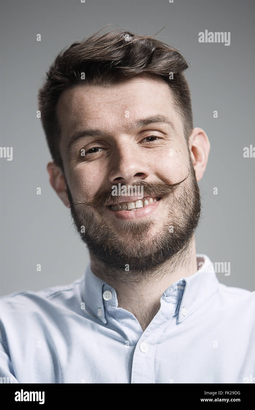 The young happy man looking at camera on gray Stock Photo - Alamy