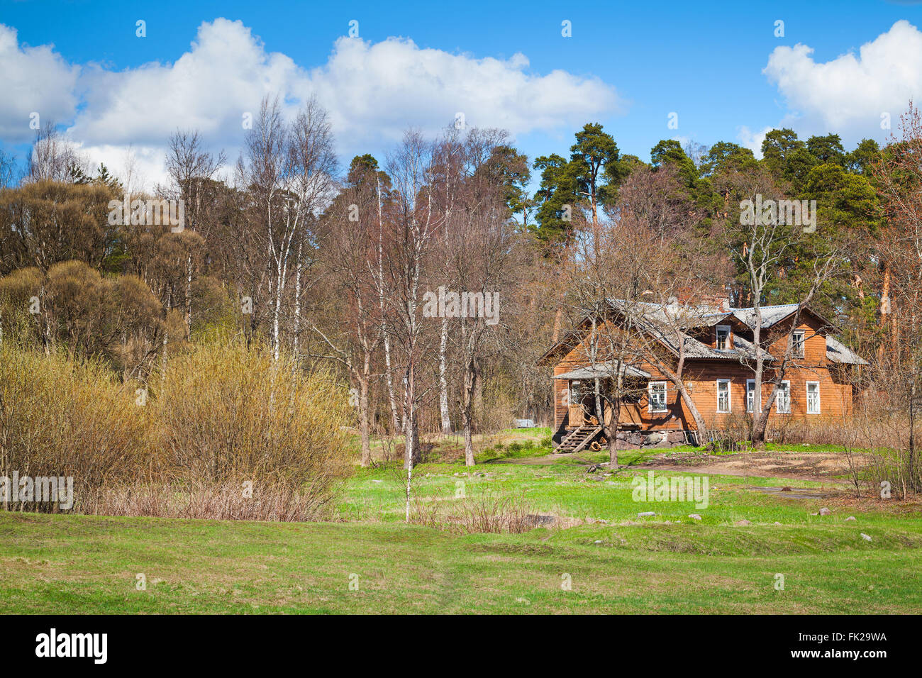 Russian rural landscape with old wooden house near spring forest Stock Photo