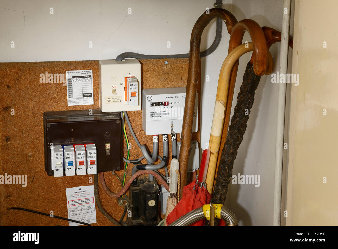 An old style electricity meter with fuses in a cupboard Stock Photo