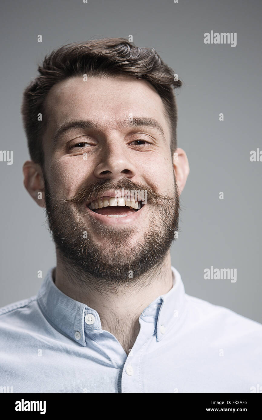The young happy man looking at camera on gray Stock Photo - Alamy