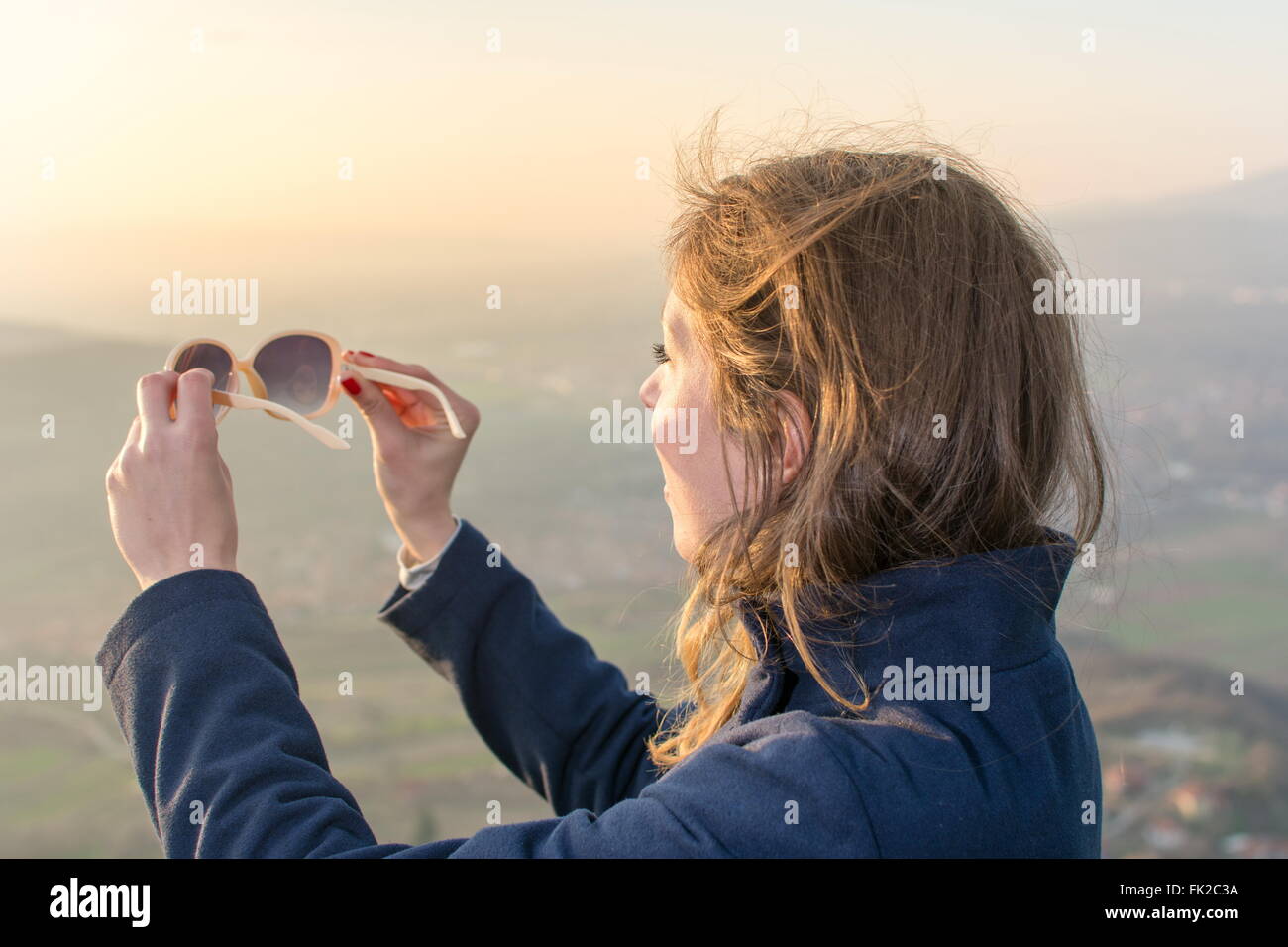 Girl on hiking trip enjoying the sunset view from above Stock Photo
