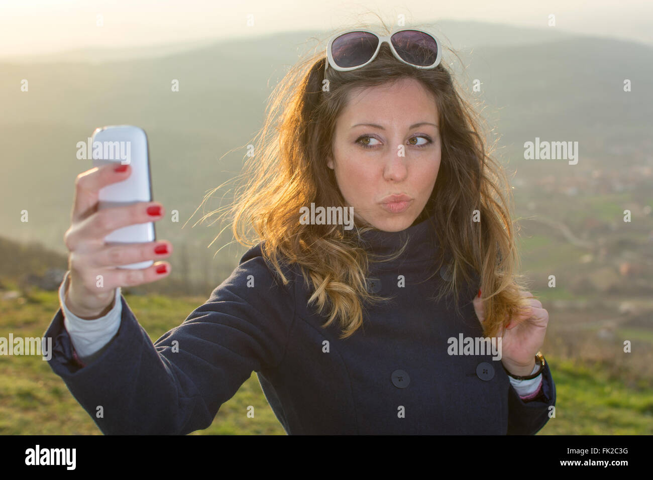 Girl taking a selfie on a hiking trip at sunset Stock Photo