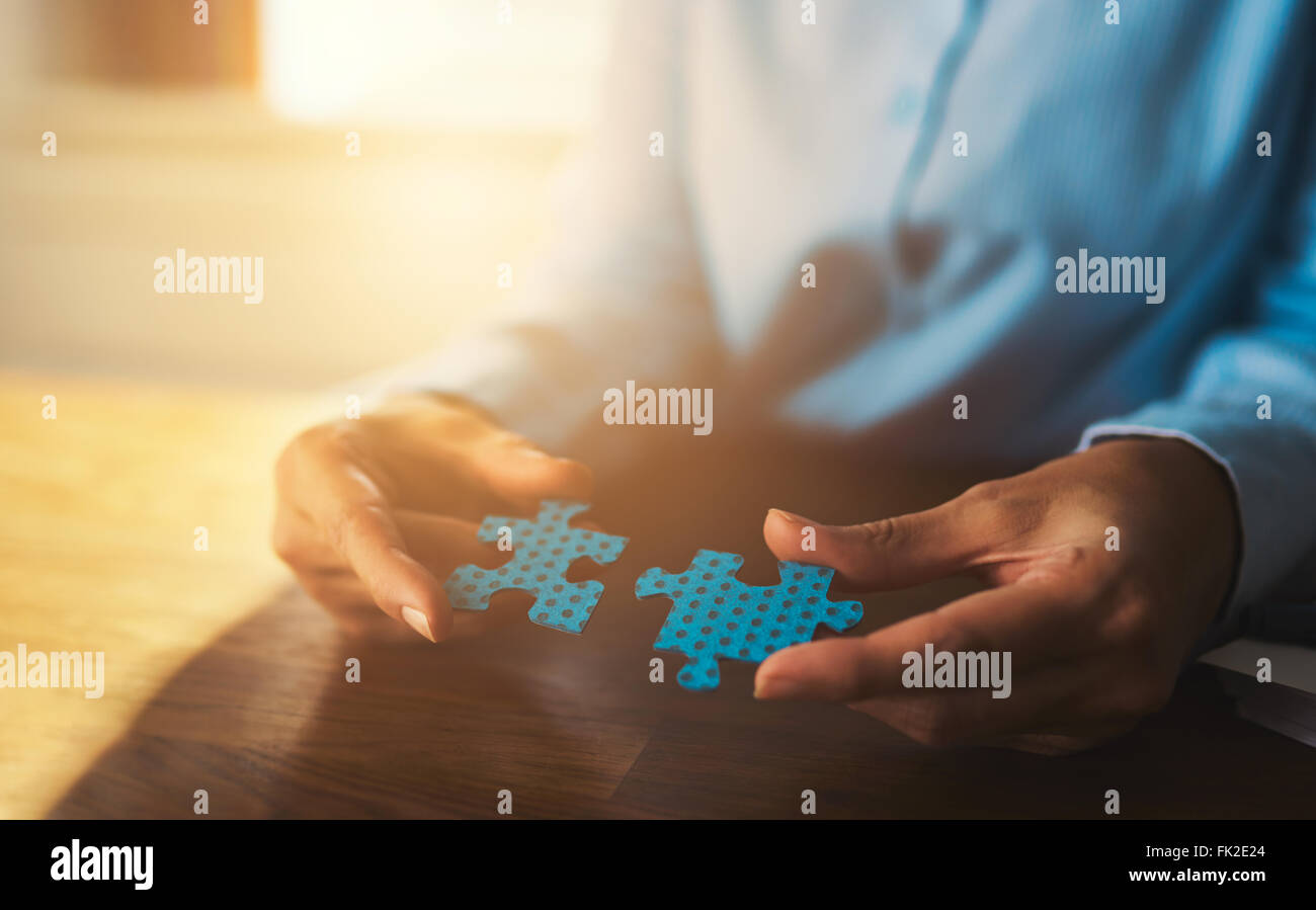 Business woman connecting puzzles, closeup of hands, success concept Stock Photo