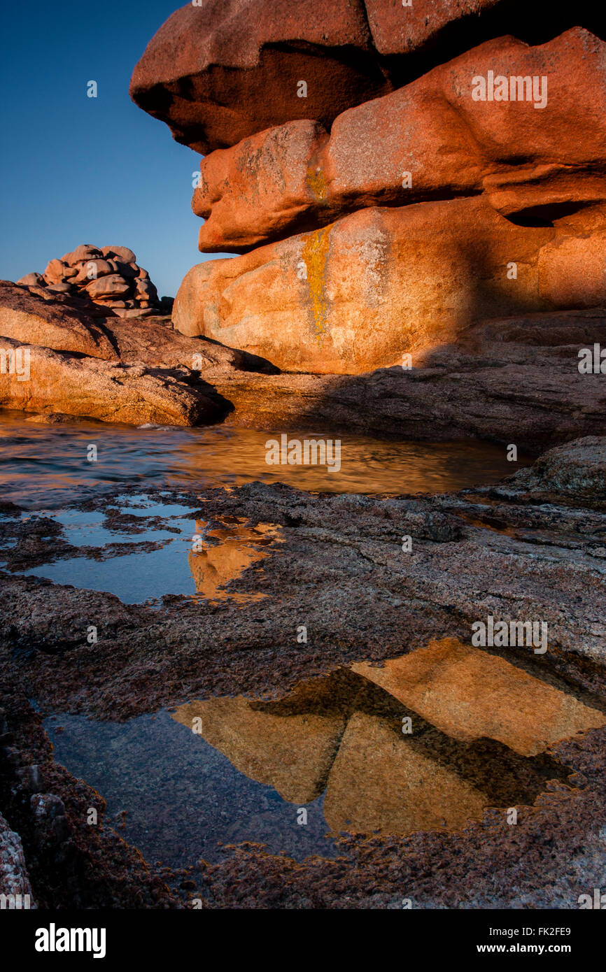 At Ploumanach the huge granit boulders by the seaside are lit with warm afternoon light Stock Photo