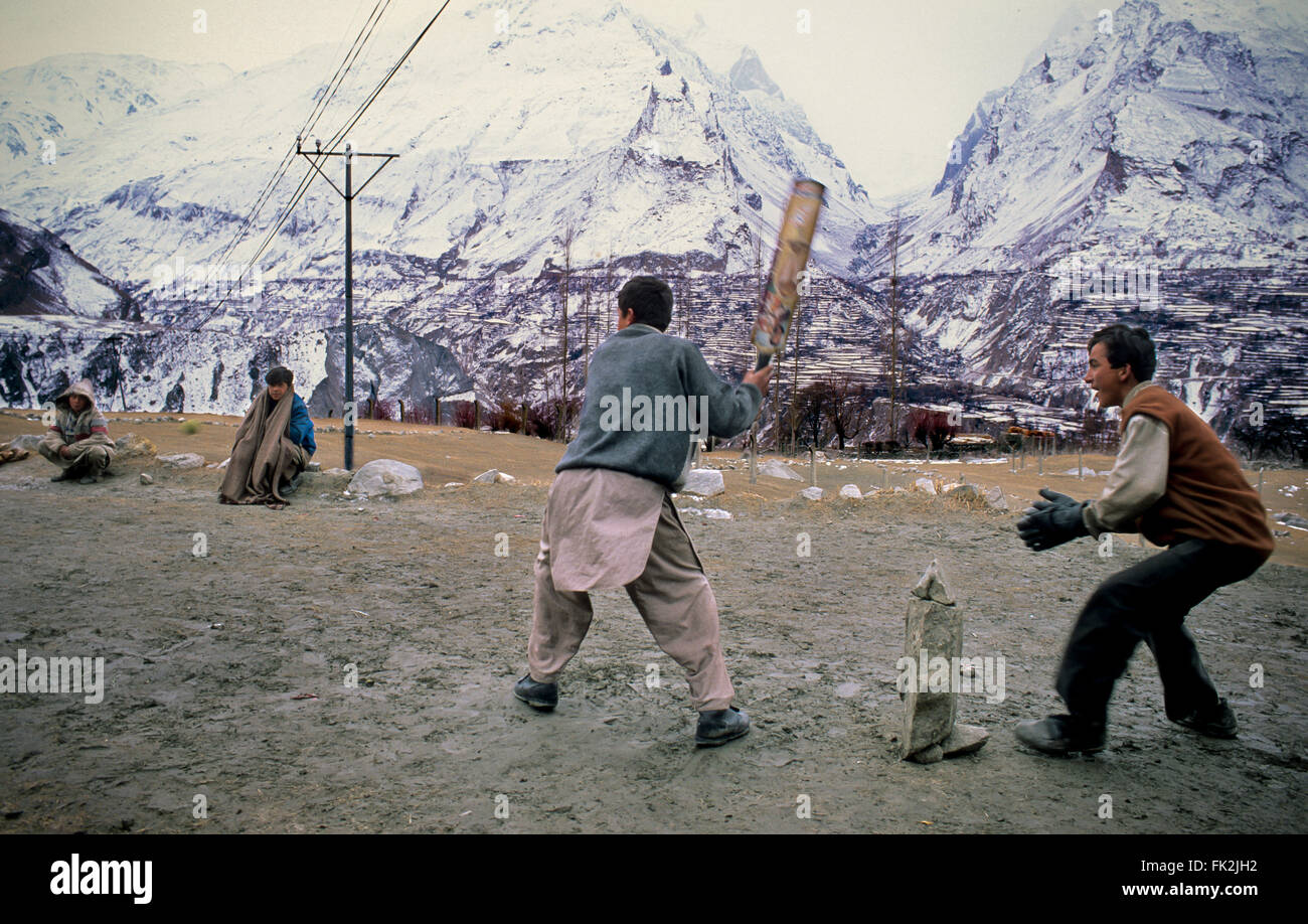 Young playing cricket in the middle of the mountains of the Karakoram range. Stock Photo