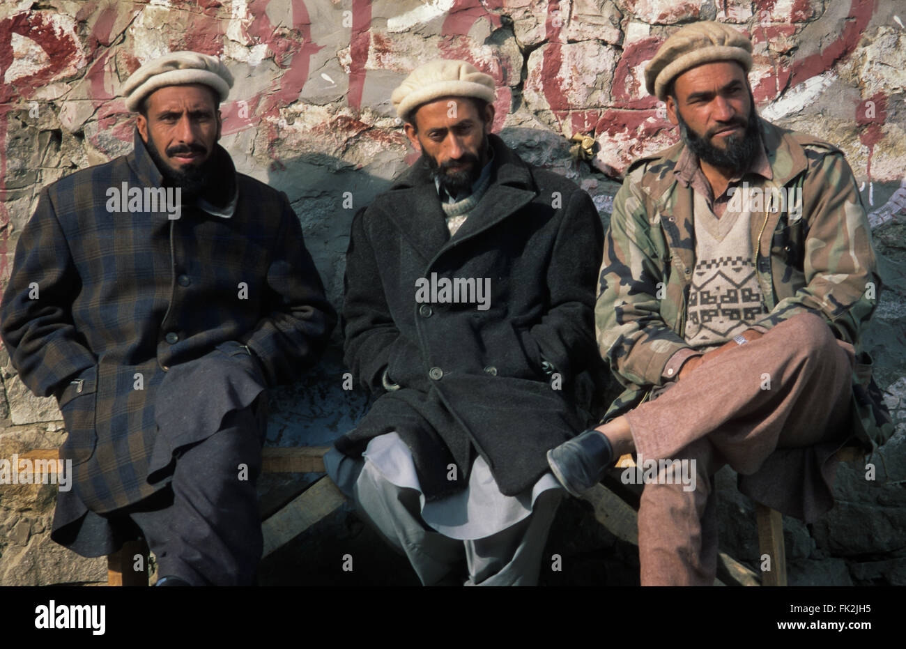 Three Pakistani men sitting on a bench in the village of Karimabad