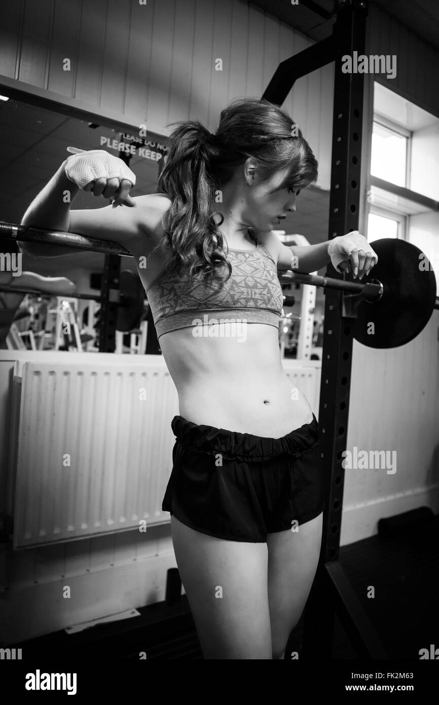 Young and beautiful female fitness competitor on a squats rack Stock Photo
