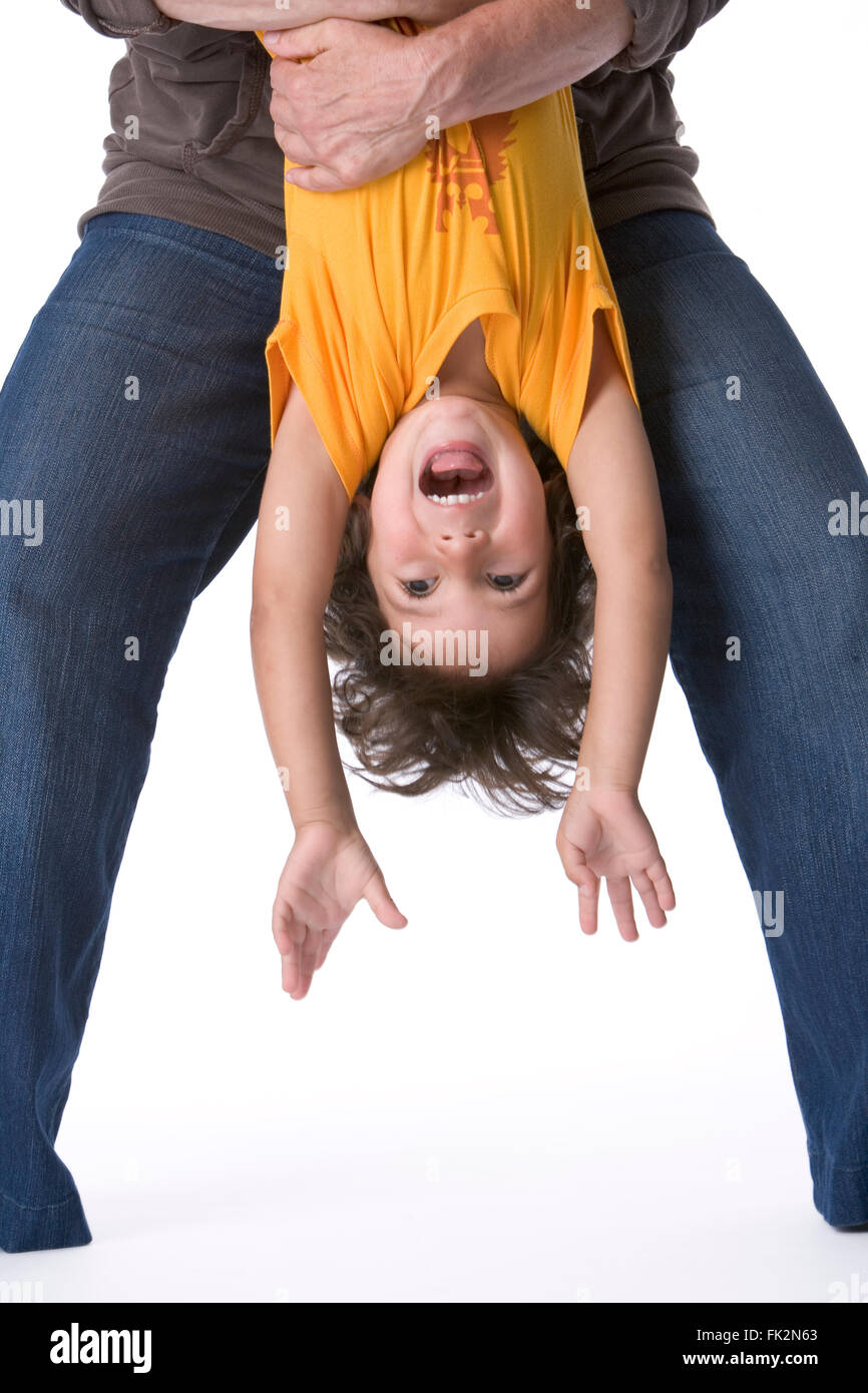 Little Boy Hanging Upside Down On White Background on white background Stock Photo