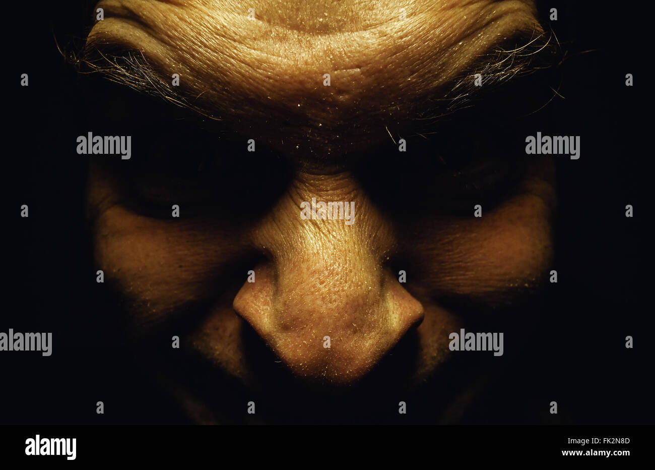 Facial expression of an ugly male face, details of eyes in dark and wrinkled skin. Stock Photo