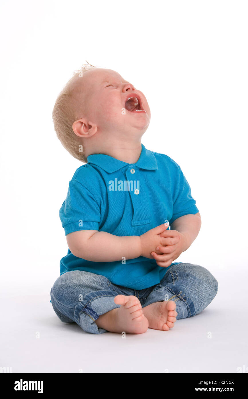 Sad toddler boy is crying very loud on white background Stock Photo