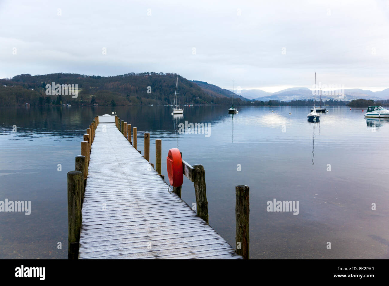 Sailboats and a pier on Lake WIndemere in early morning - Cumbria, England Stock Photo