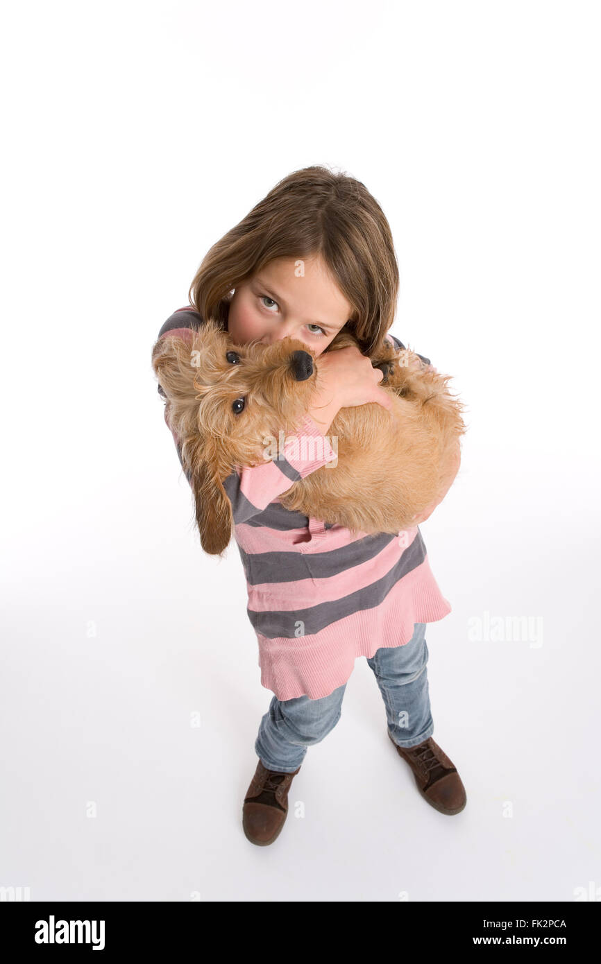 Little Girl Is Carrying Her Pet Dog Full Lenght on white background Stock Photo