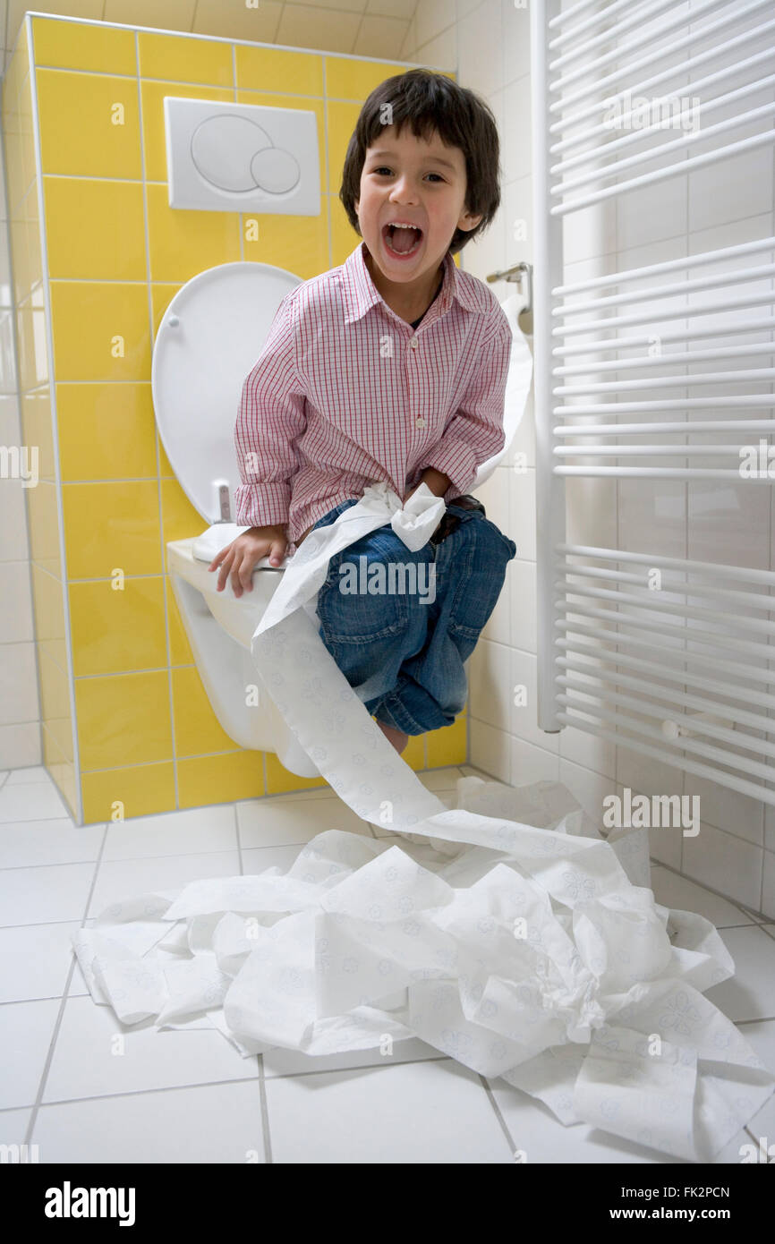 Little Boy Has A Lot Of Fun With Toiletpaper In The Bathroom Stock Photo
