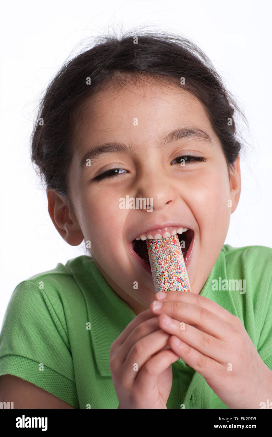 Little Girl Is Eating Icecream With An Enthousiastic Expression on white background Stock Photo