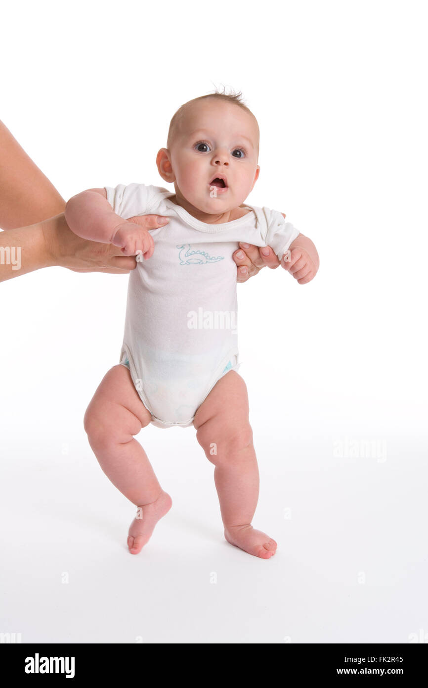 Baby Girl Is Trying To Walk with help from parents hands On White ...