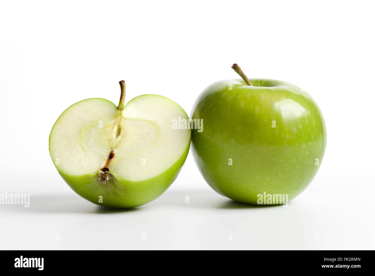 One and a half green Granny Smith apple on white background Stock Photo