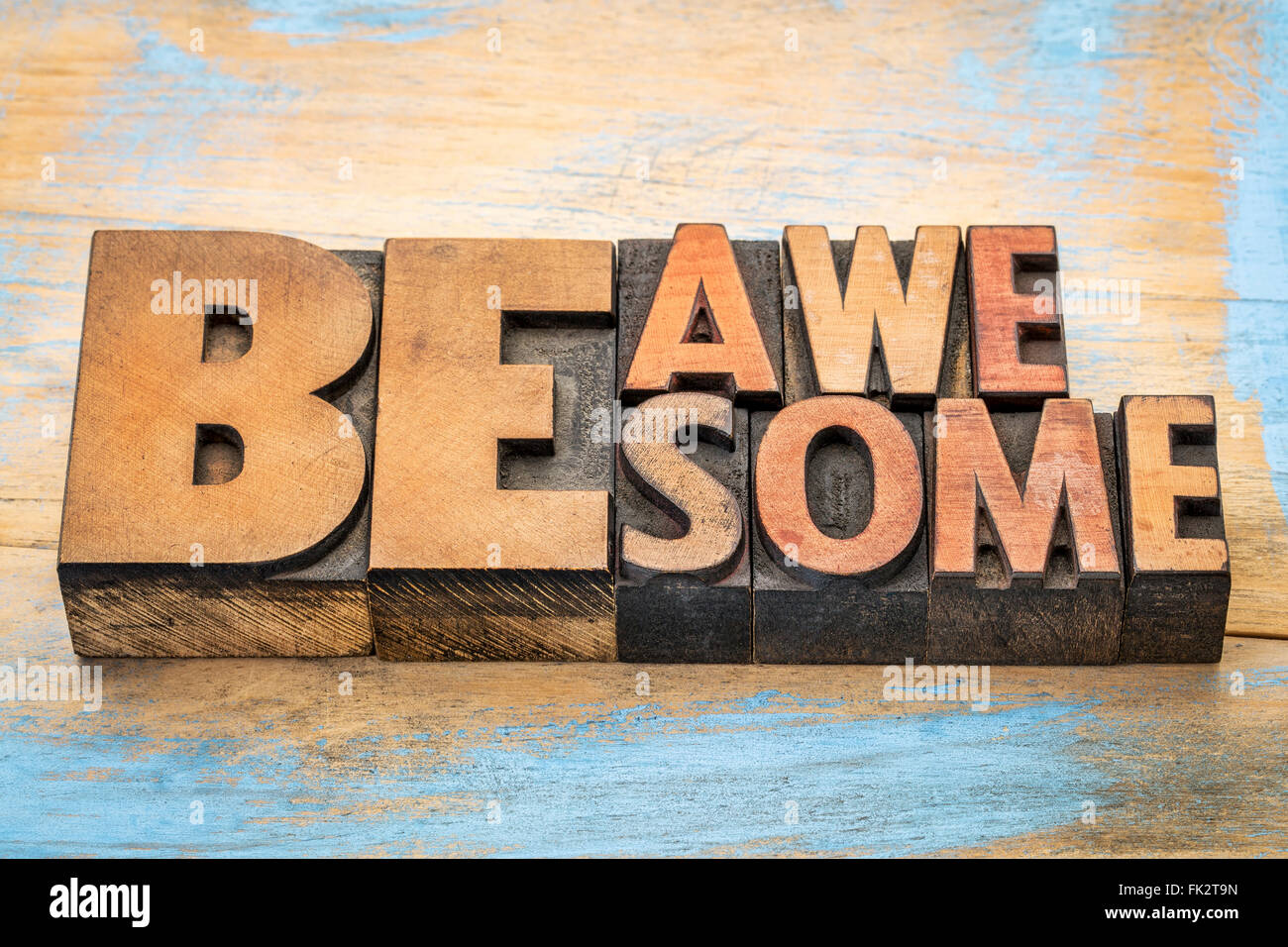 be awesome words in vintage letterpress wood type blocks against grunge painted wood Stock Photo