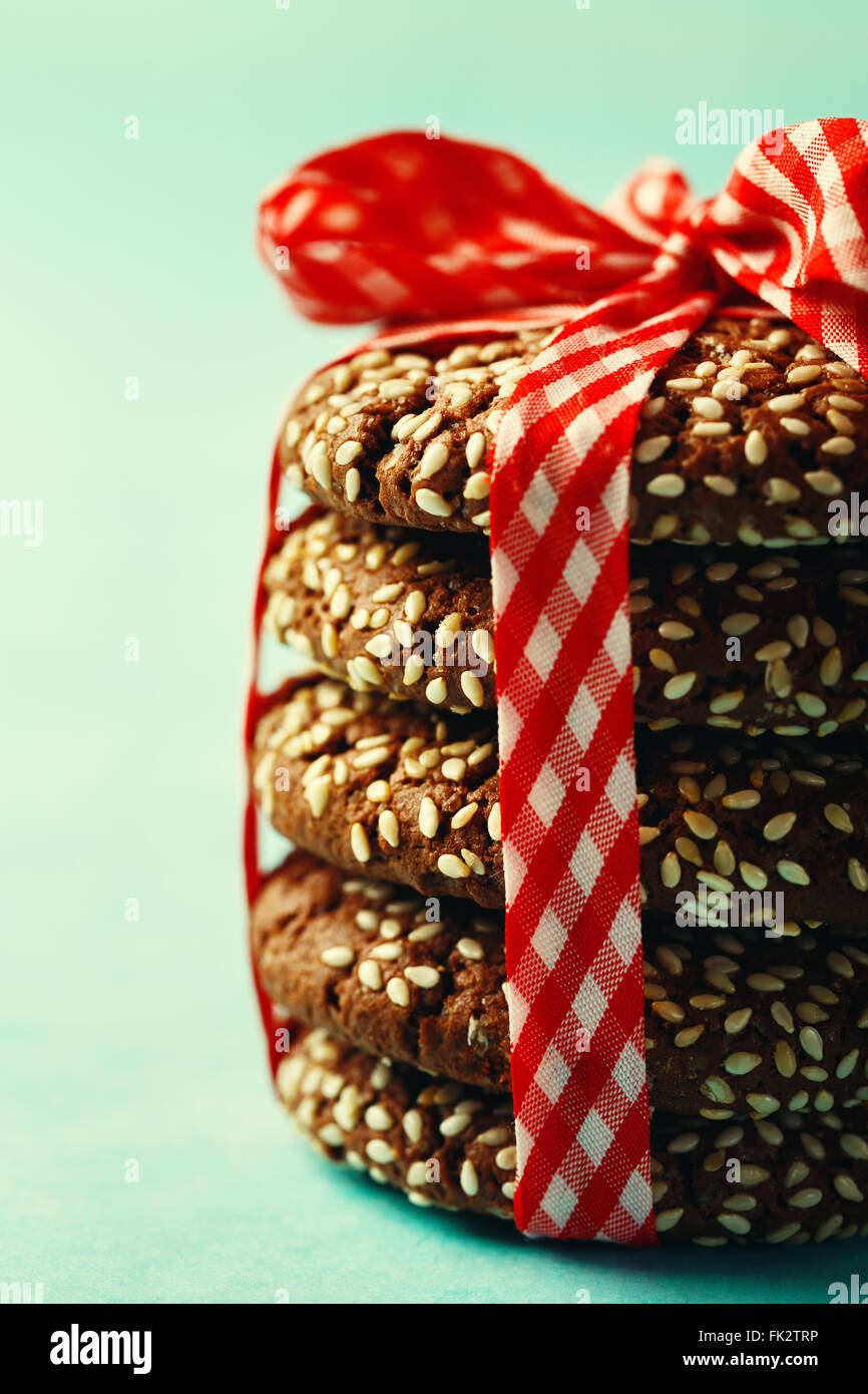 Stack of Fresh Natural Homemade Cookies with Sesame Decorated with Red Checked Ribbon. Close-up, Side View, Selective Focus. Ima Stock Photo