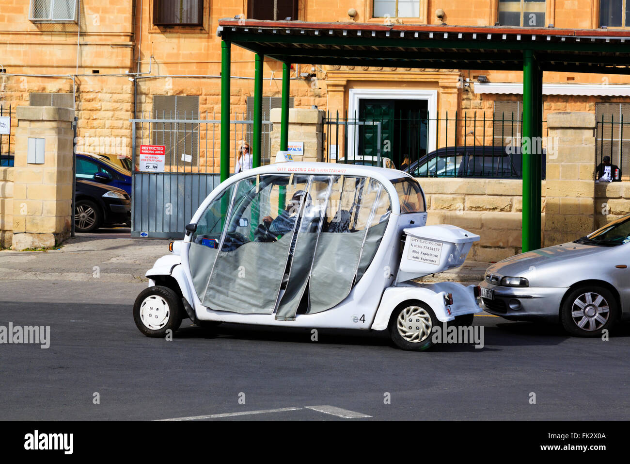 White, electric minicab waiting for passengers, Floriana, Valletta, Malta Stock Photo