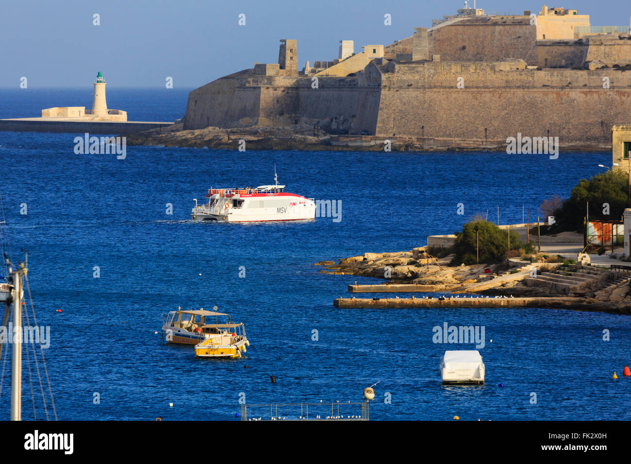 The Sliema - Valletta ferry crossing Grand harbour towards the walls of Fort St Elmo. Stock Photo