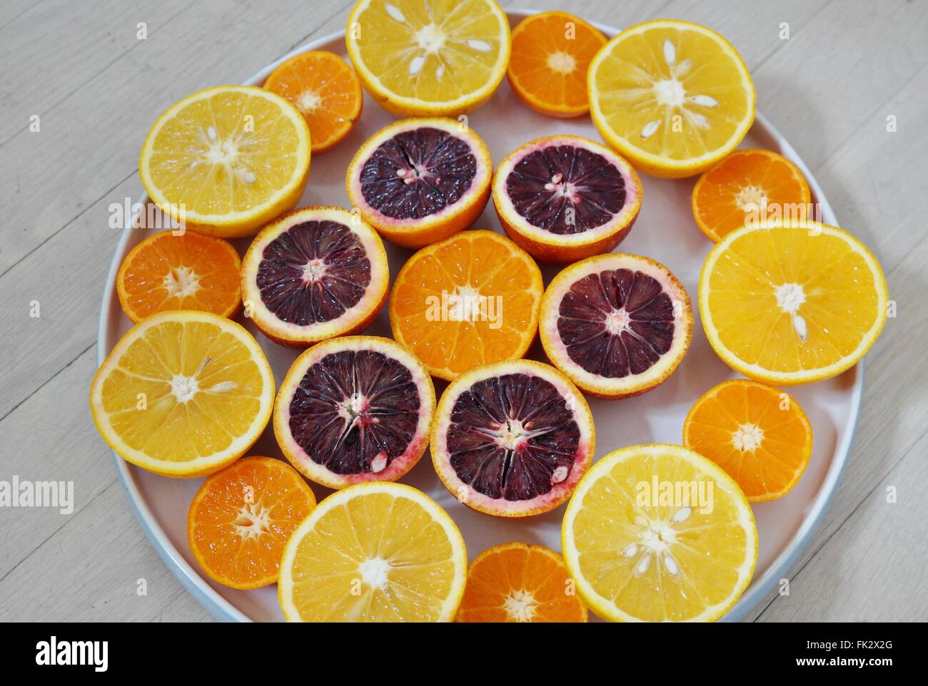 Ruby red blood oranges, navel oranges, and clementines cut in half on a
