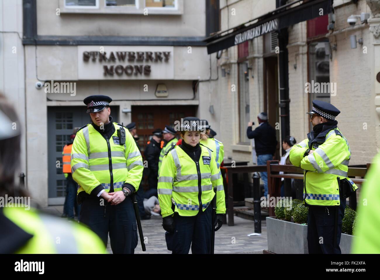 London, UK. 6th March 2016. Police stand guard as protester can be seen laying on the ground behind. Credit:  Marc Ward/Alamy Live News Stock Photo