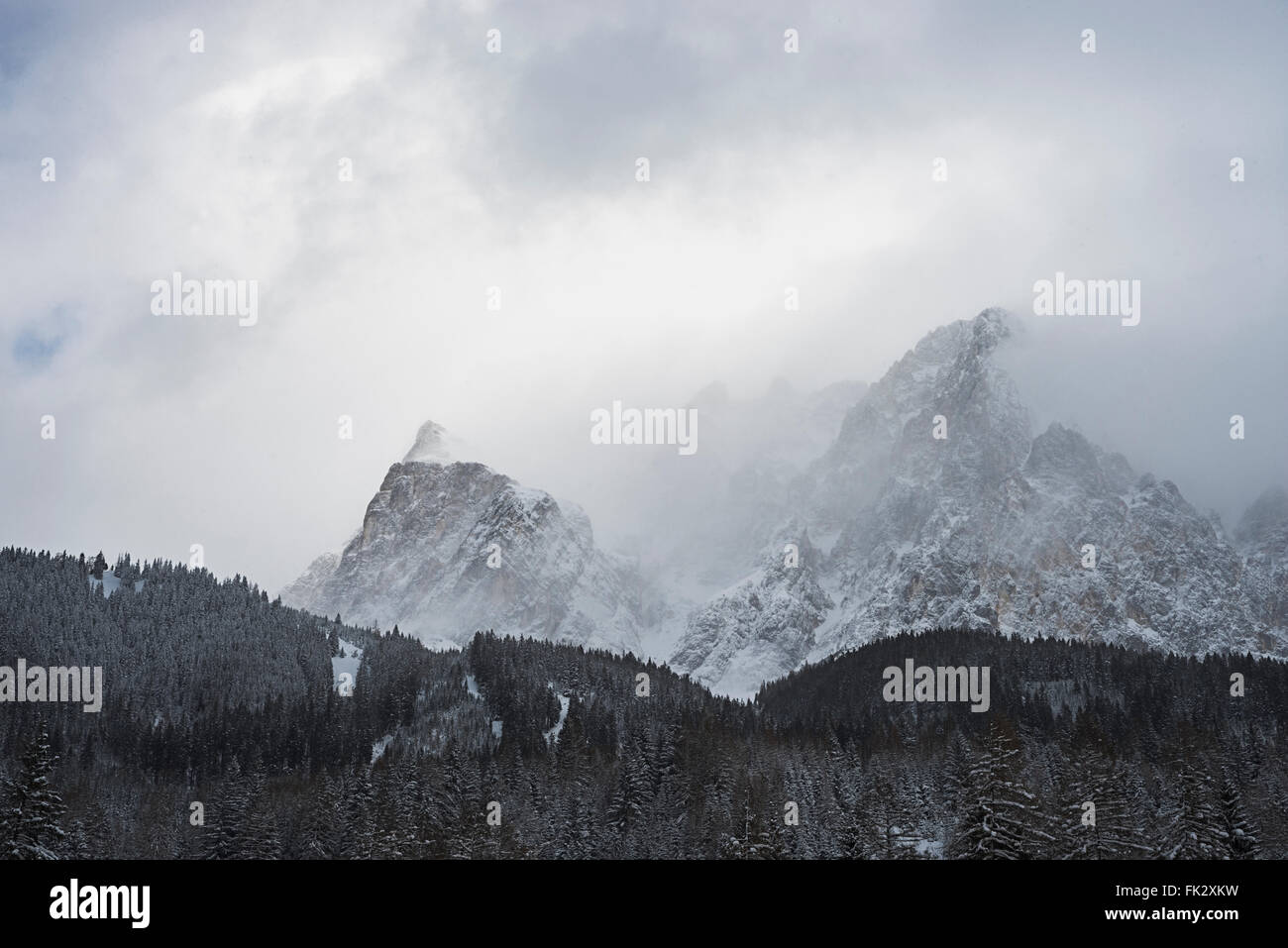 Snow and clouds draw on the cliffs and rocks of the Wetterstein mountain massif at Ehrwald ,Tirol, Austria on a winter dayra Stock Photo