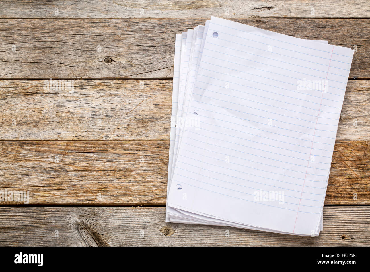 stack of blank notebook pages on a rustic, weathered wood background Stock Photo