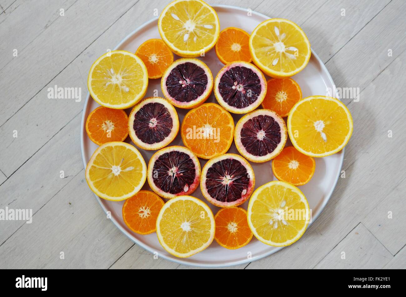 Ruby red blood oranges, navel oranges, and clementines cut in half on a