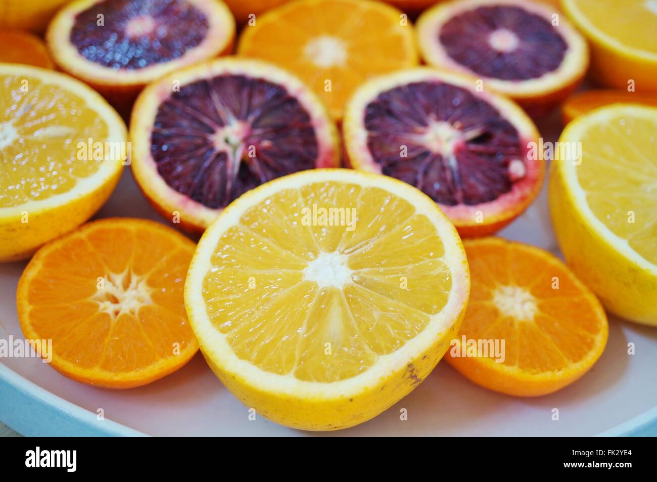 Ruby red blood oranges, navel oranges, and clementines cut in half on a