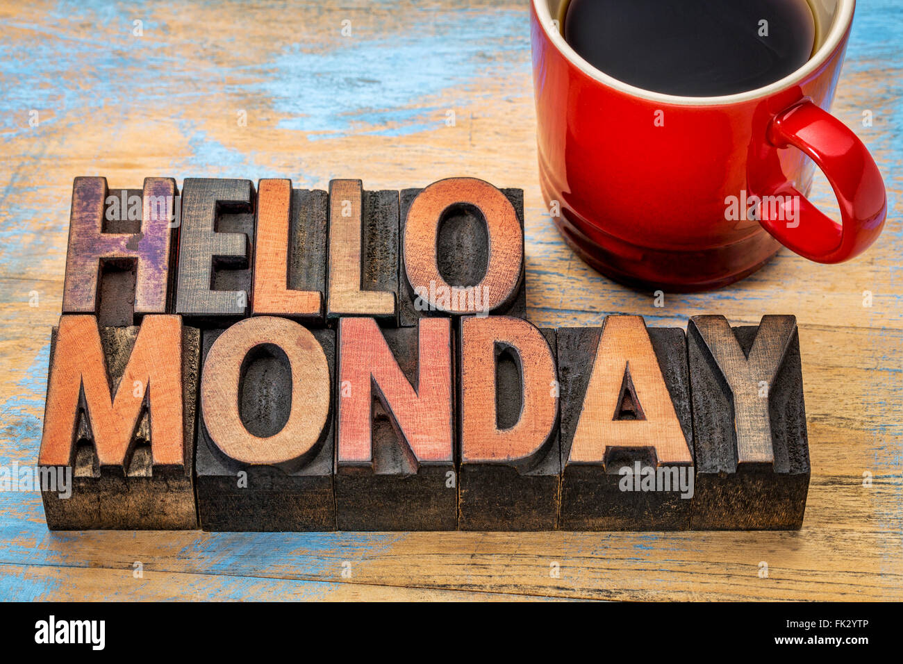 Hello Monday  word abstract in vintage letterpress wood type printing blocks stained by color inks with a cup of coffee Stock Photo