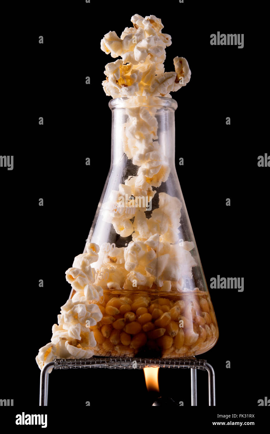 popcorn cooking in oil in flask with flame Stock Photo