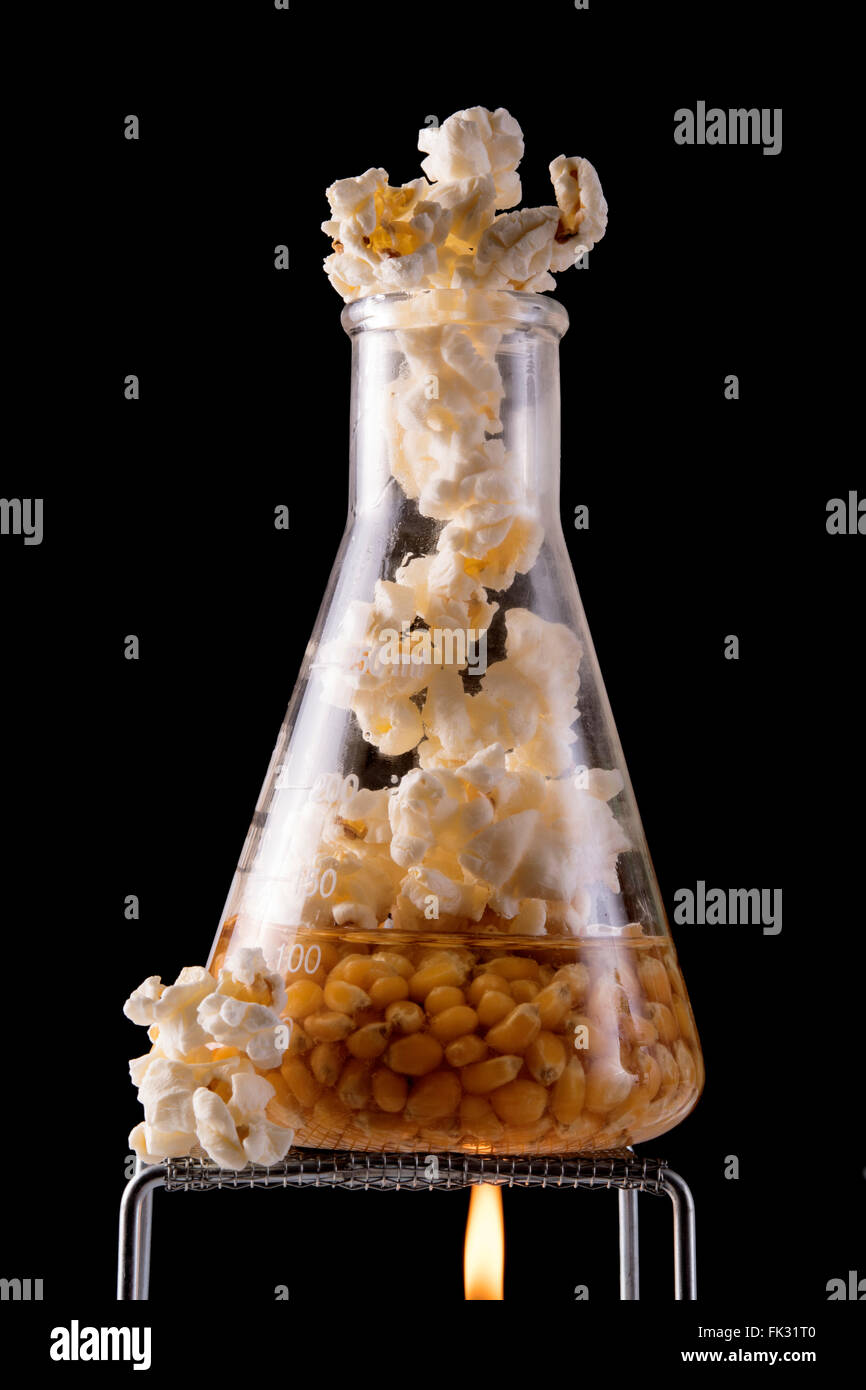 popcorn cooking in oil in flask with flame Stock Photo