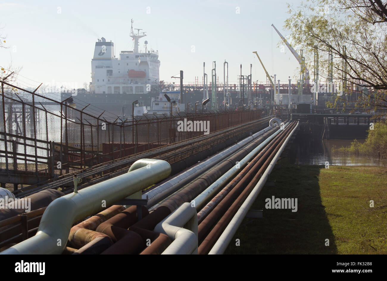 Delivery pipes for oil and gas stretching out to freighters docked on the Mississippi River.  Garyville, Louisiana, USA. Stock Photo