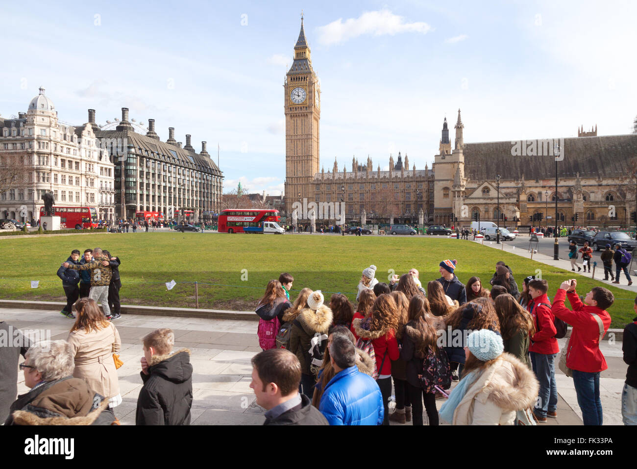 Tourists in Parliament Square with the Houses of Parliament and Big Ben, central London UK Stock Photo