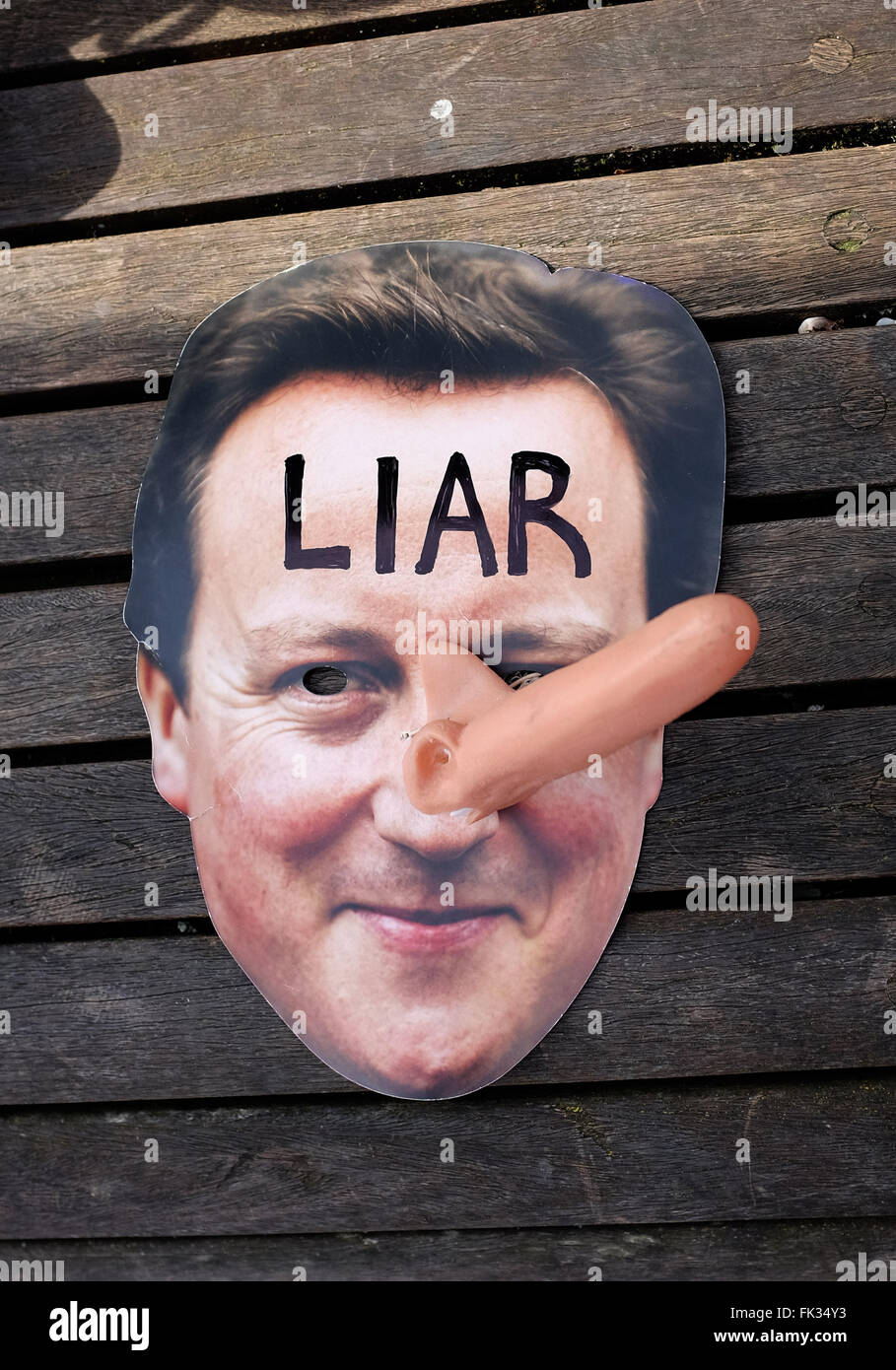 British Prime Minister David Cameron face mask with long Pinocchio style nose and Liar written on forehead Stock Photo