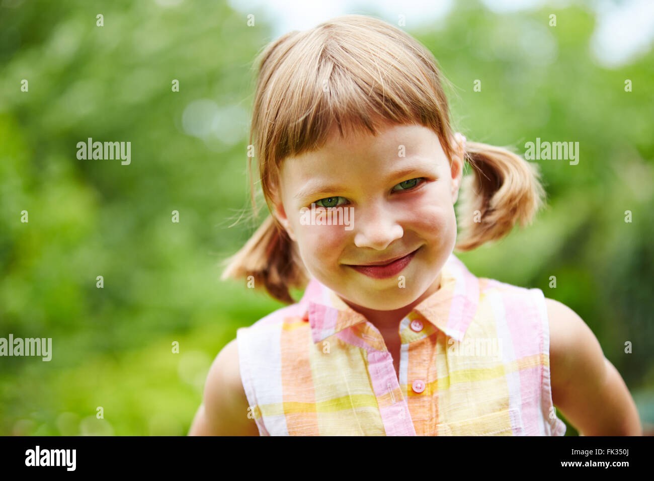 Happy girl smiling in a green garden in spring Stock Photo - Alamy
