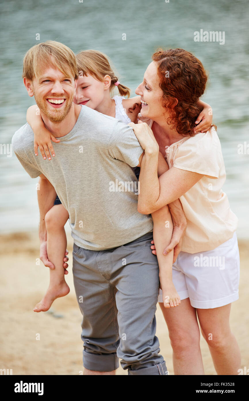 Happy family taking family holiday on beach of sea in summer Stock Photo