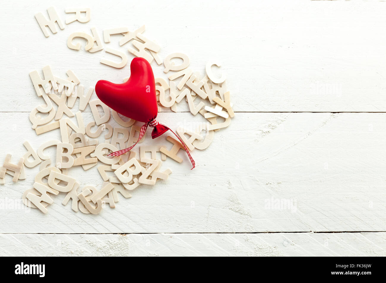 Scattered wooden letters and a red heart Stock Photo - Alamy