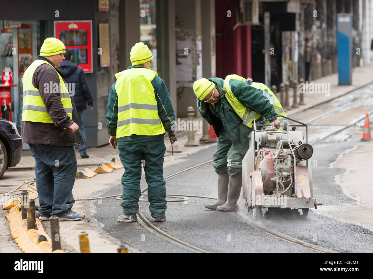 Sofia, Bulgaria - February 27, 2016: Transportation workers are cutting the asphalt at the tram rails during a repairment. Stock Photo