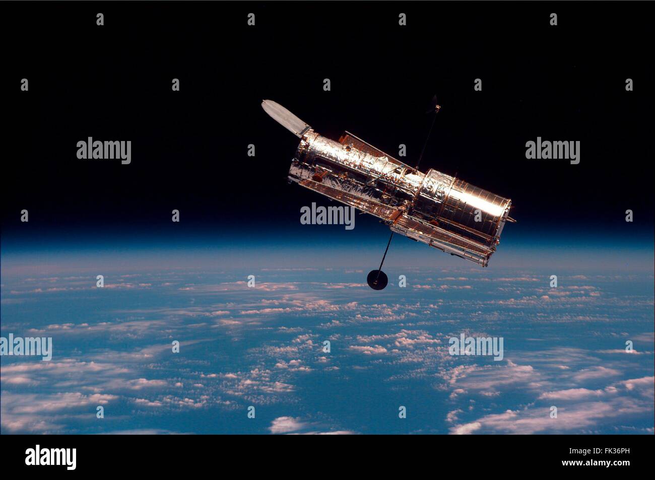 The Hubble Space Telescope floats above the Earth after being released by the Space Shuttle rtobotic arm following repairs and upgrades by the STS-081 astronauts February 19, 1997 in Earth Orbit. Stock Photo