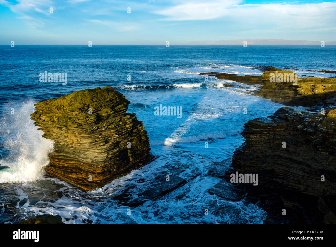 Sea stack from the coastal path near Scarfskerry, Caithness, Scotland, UK.  In the distance is Hoy in the Orkney Islands. Stock Photo