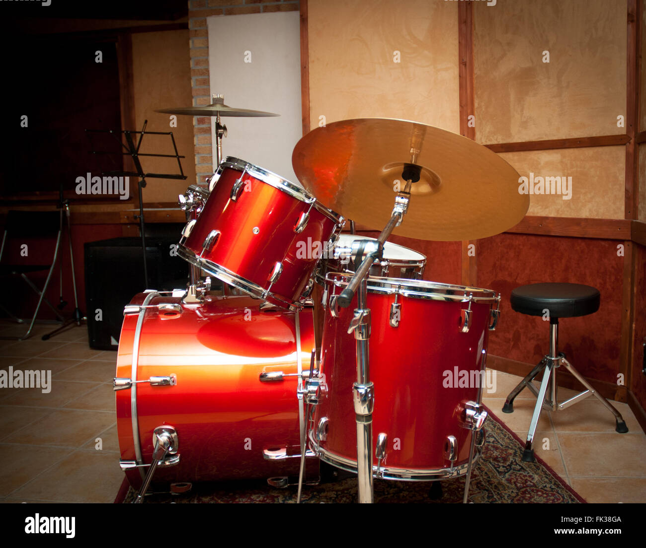 Red drum instrument with tom and cymbal in wooden recording studio