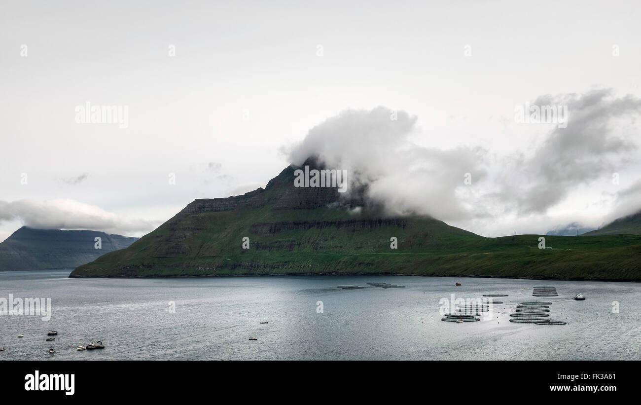 Fog lying on mountains. Fuglafjord, Faroe islands, Denmark, Europe. Stock Photo