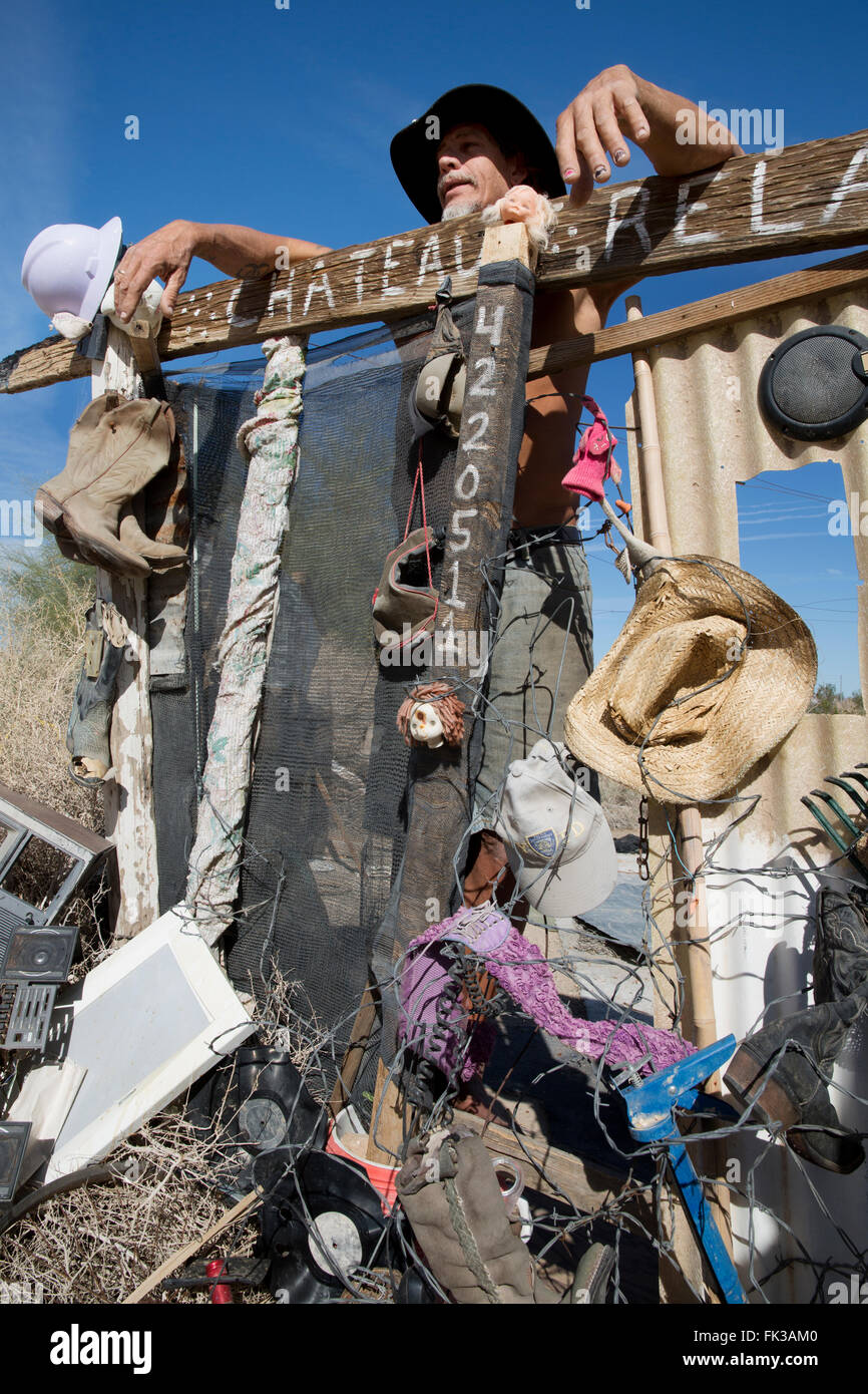 Karibe, a resident of Slab City, stands at the gate to his encampment, Niland, California USA Stock Photo